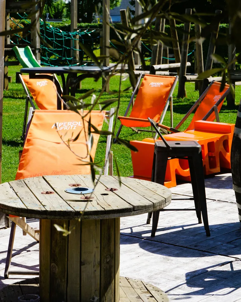 Transats orange et tonneaux sur la terrasse extérieure