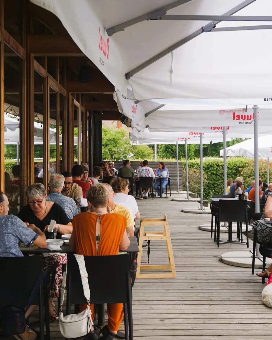 Grandes tablées sous le chapiteau de la terrasse, un soir d'été